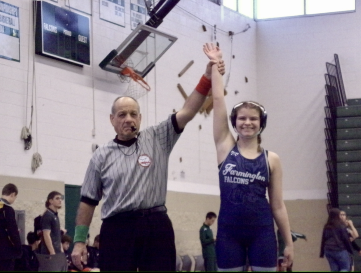 Ella Baron, wrestling captain, smiling for a photo as she is declared the winner of a match