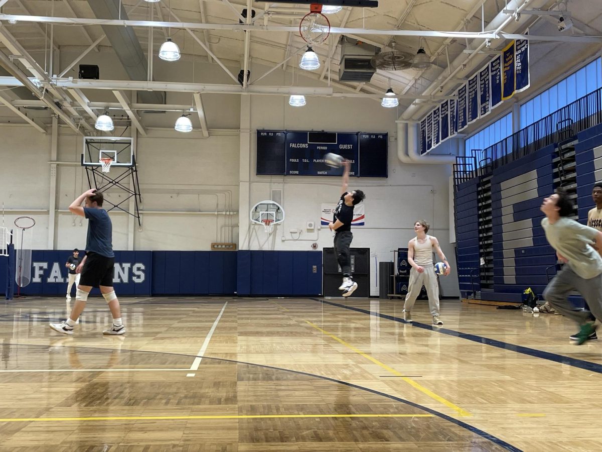 Player makes a jump serve at the baseline.