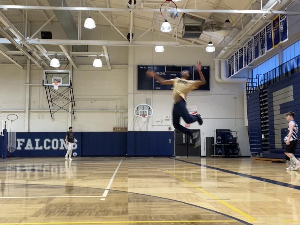 Player makes a jump serve at the baseline.